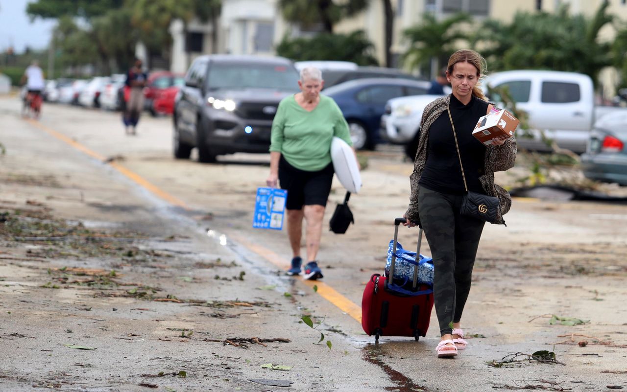 Residents leave with their belongings after an apparent tornado spawned from Hurricane Ian in Delray Beach on Wednesday.