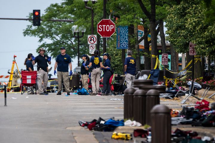 FILE - Members of the FBI Evidence Response Team Unit investigate in downtown Highland Park, Ill., on July 5, 2022, the day after a deadly mass shooting at a Fourth of July Parade. According to a lawsuit filed Wednesday, Sept. 28, 2022, in Illinois, the gunmaker Smith & Wesson illegally targeted young men at risk of violence with ads for firearms, including the 22-year-old gunman accused of opening fire on the Independence Day parade in suburban Chicago and killing seven people. (Ashlee Rezin/Chicago Sun-Times via AP, File)