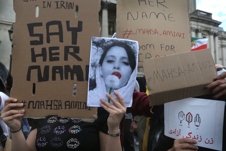 Protesters hold up signs with Amini's name Saturday in London.