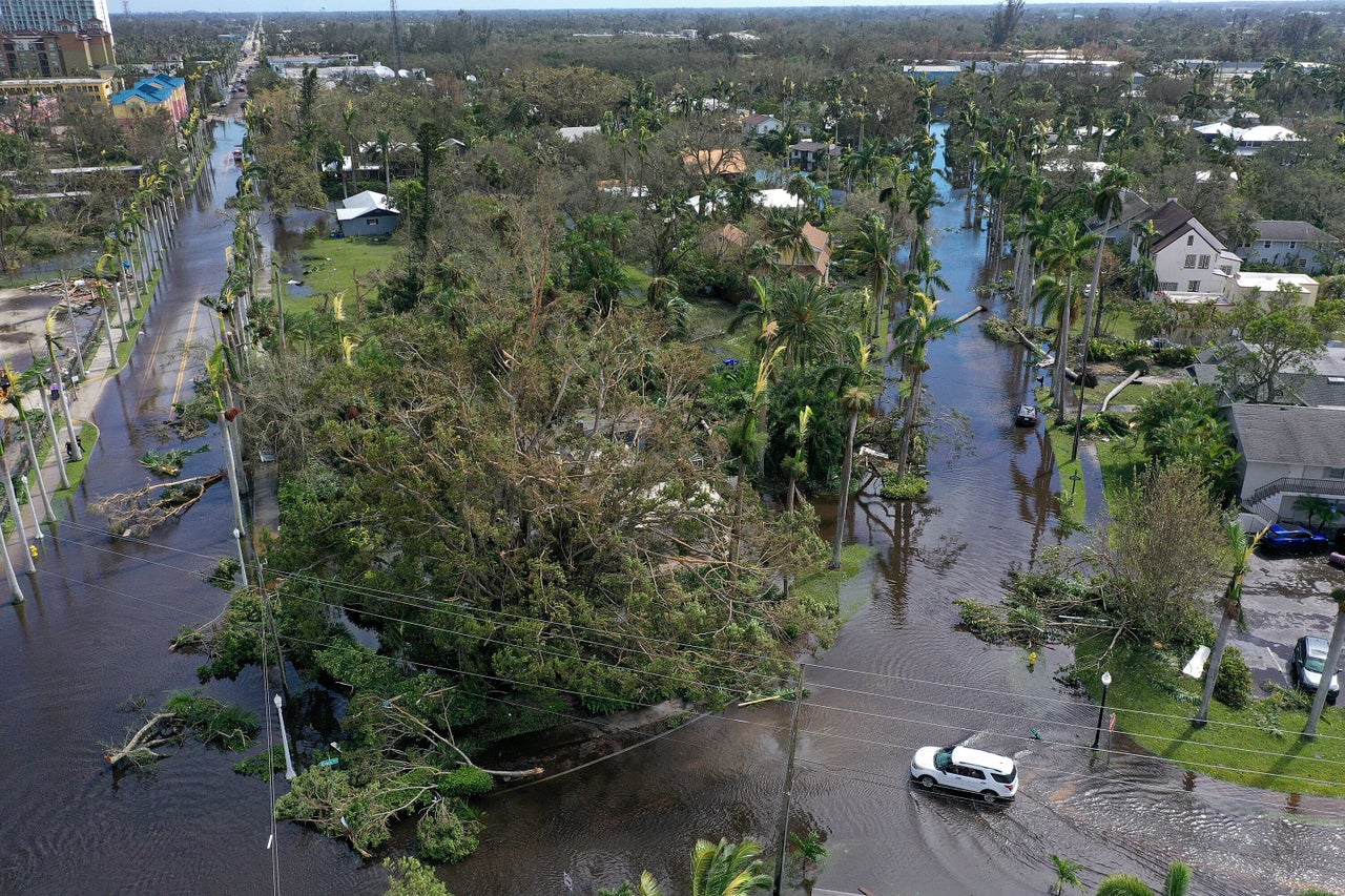 Vehicles make their way through a flooded area after Hurricane Ian made landfall Sept. 29 in Fort Myers.