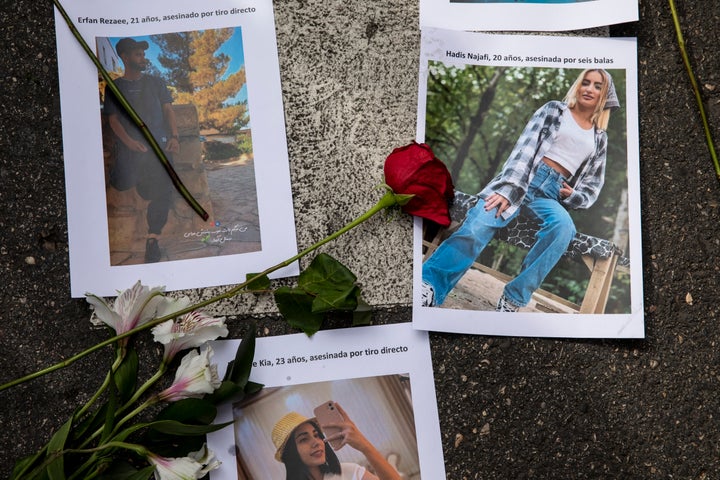 Pictures of victims of police violence in Iran are placed with flowers on the ground during a protest over Amini's death outside the Iranian Embassy in Madrid on Wednesday.