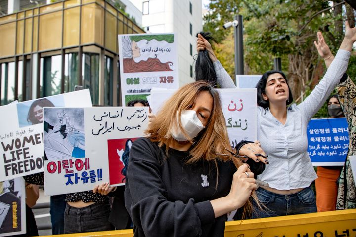 A member of the Iranian community cuts her hair during a rally outside the Iranian Embassy in Seoul, South Korea, on Wednesday.