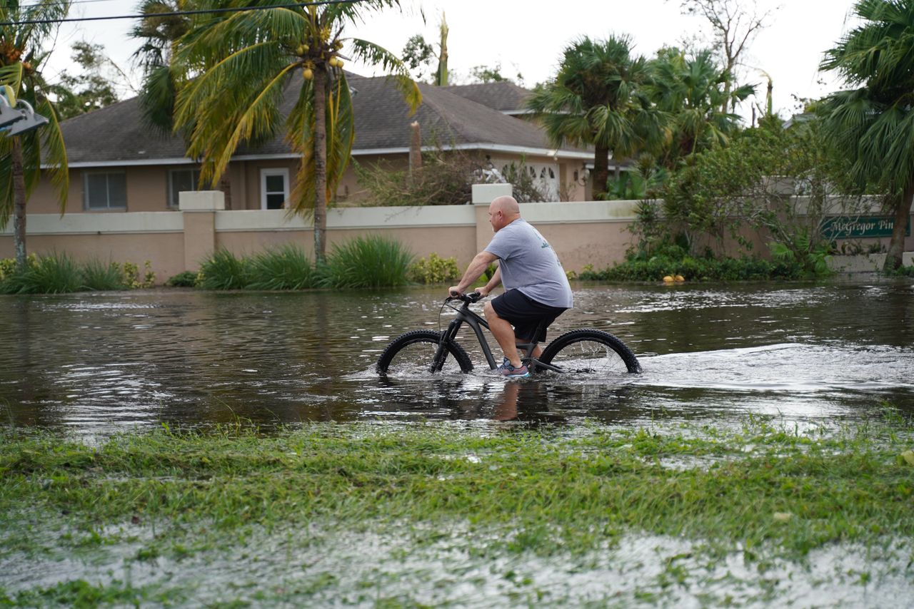 A man tries to ride bike in the flooding in Fort Myers on Sept. 29. 