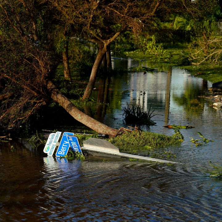 Μια πεσμένη οδική πινακίδα και πεσμένα δέντρα φαίνονται κοντά σε πλημμυρισμένο ποτάμι μετά τον τυφώνα στην περιοχή Punta Gorda της Φλόριντα, Ηνωμένες Πολιτείες στις 29 Σεπτεμβρίου 2022.