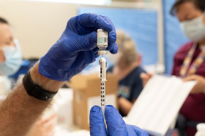Volunteer pharmacist Foster Knutson fills a syringe with a dose of a smallpox and monkeypox vaccine during an Aug. 20 clinic session at Abrams Public Health Center in Tucson, Arizona.