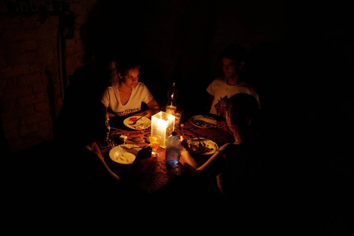 Una familia se ilumina con una vela mientras cena en La Habana