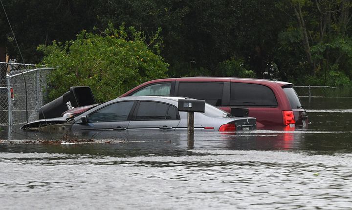Cars are submerged in a flooded Orlando street in the aftermath of Hurricane Ian. 
