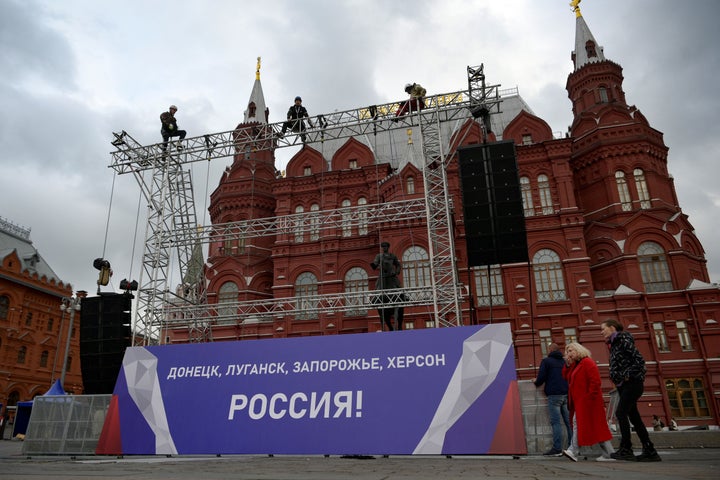 Workers fix a banner reading "Donetsk, Lugansk, Zaporizhzhia, Kherson - Russia!" on top of a construction installed in front of the State Historical Museum outside Red Square in central Moscow on September 29, 2022.