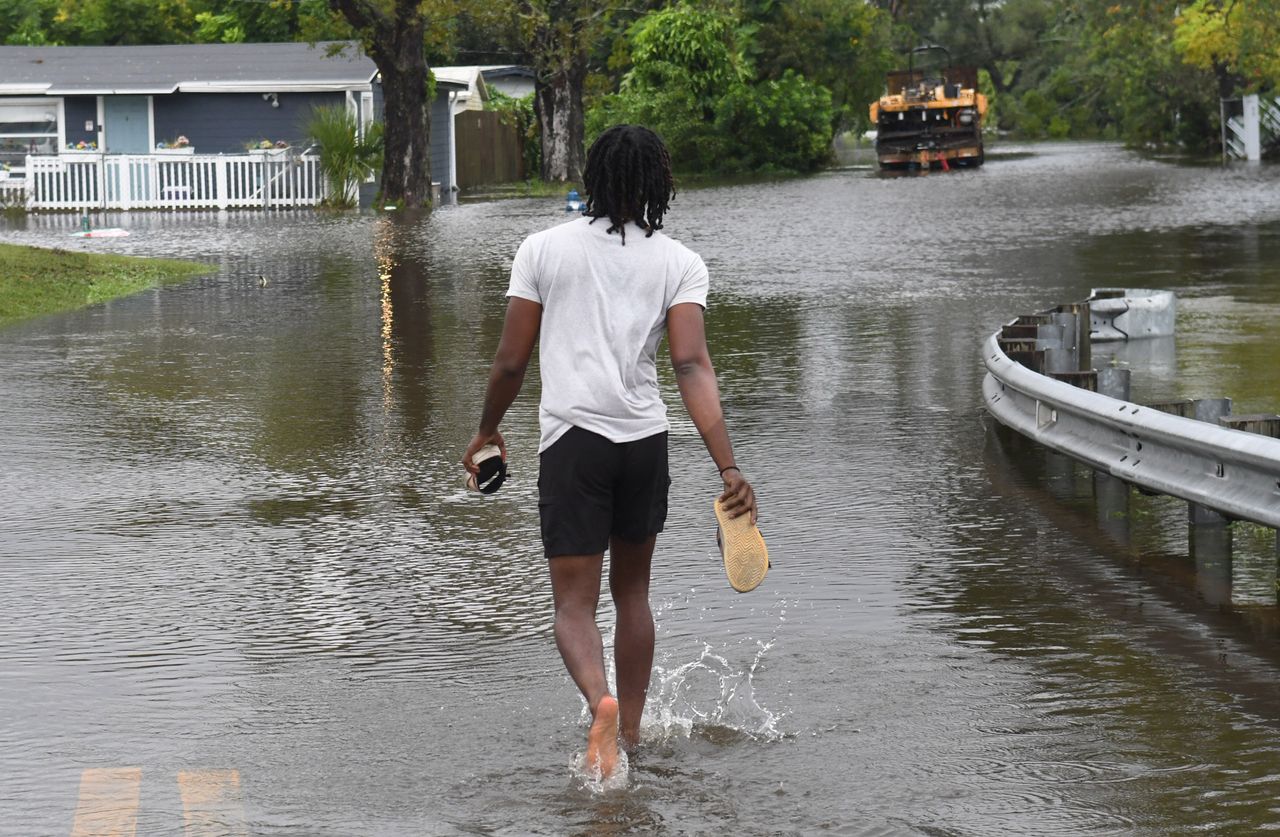 A man walks into a flooded street to check on his mother in the aftermath of Hurricane Ian on Sept. 29 in Orlando. 