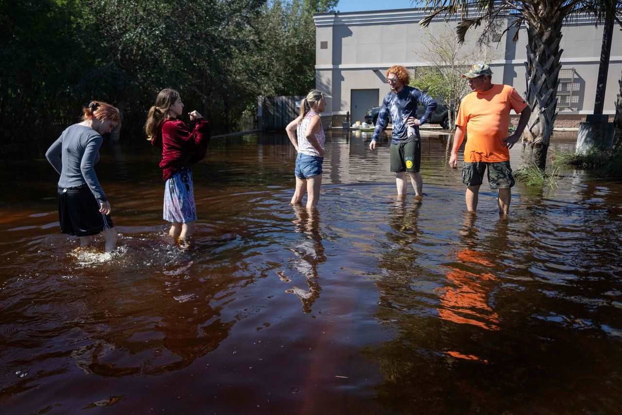 A family gathers in a flooded parking lot in New Smyrna Beach, Florida, on Sept. 30.