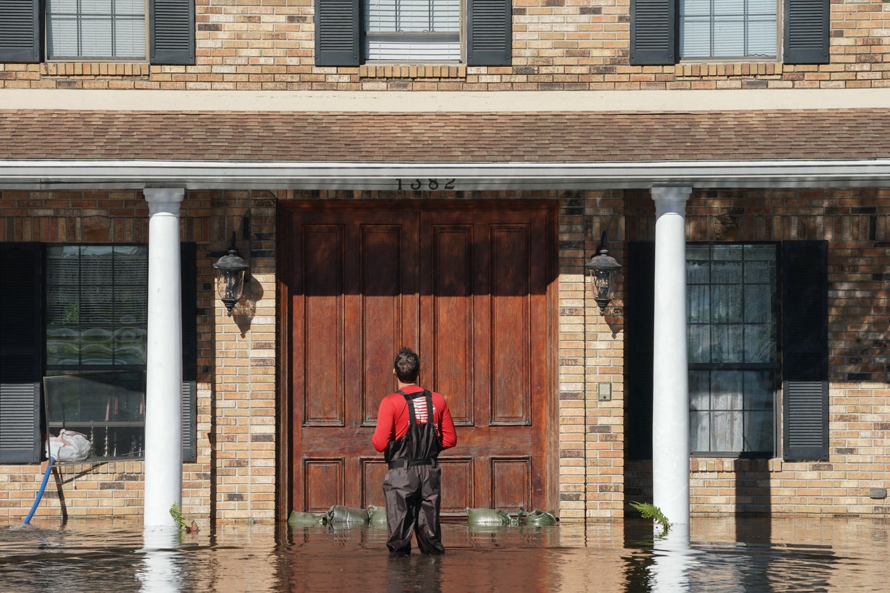 A man stands in floodwaters in front of his house on Sept. 30, 2022, in Kissimmee, Florida.