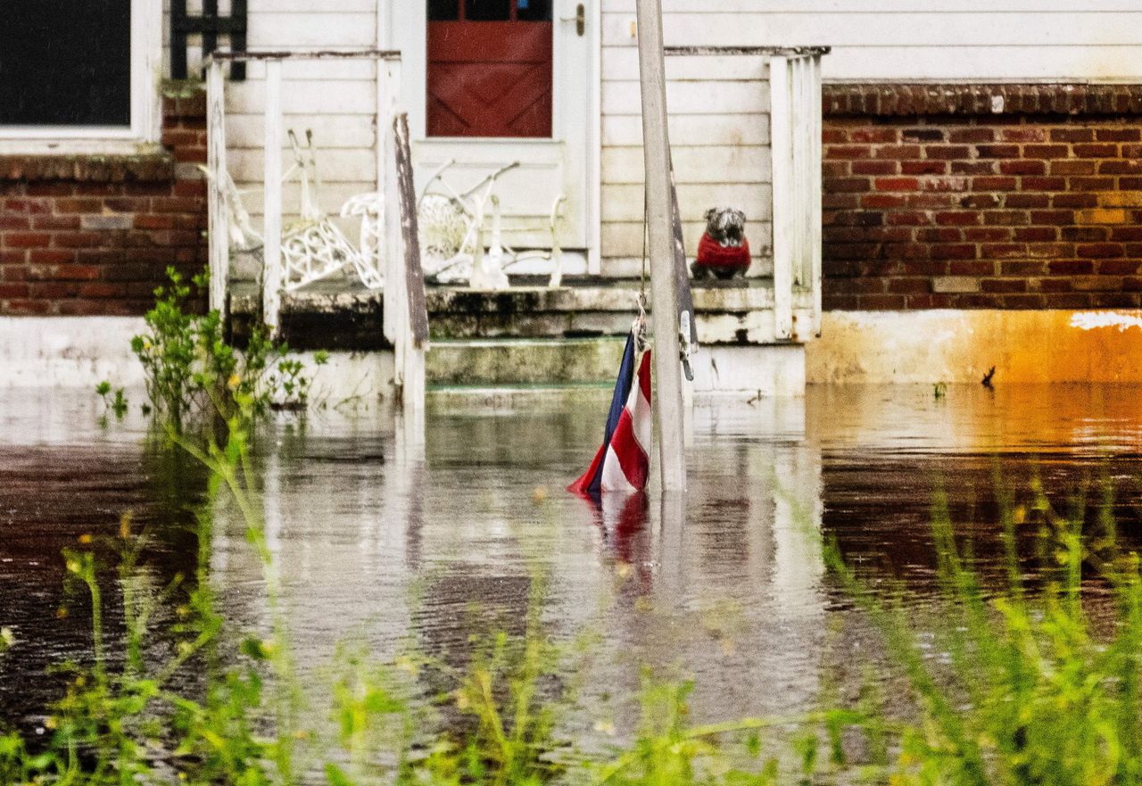 An American flag lies partially submerged in the flooded front yard of a house in New Smyrna Beach on Sept. 30.