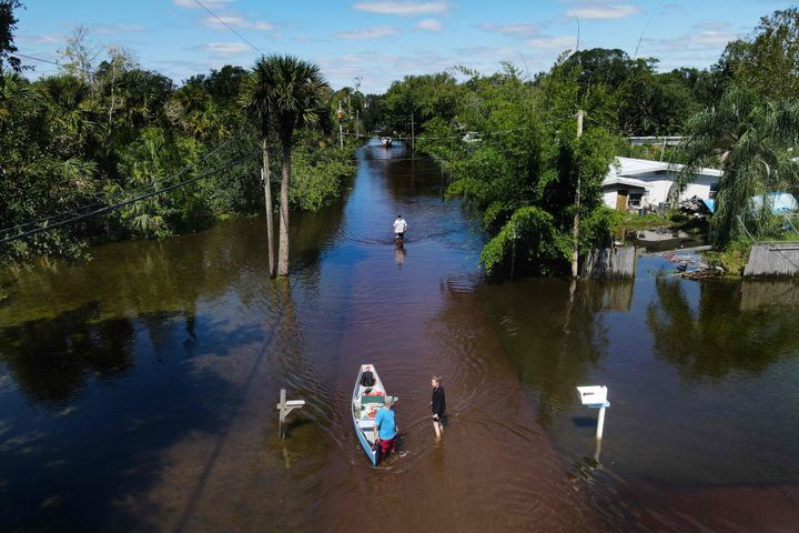 In this aerial view, a man tows a canoe through a flooded street of his neighborhood in New Smyrna Beach, Florida, on September 30, 2022, after Hurricane Ian slammed the area. - Rescue workers went door-to-door in Florida on Friday to assist survivors of Hurricane Ian as the Carolinas braced for the arrival of the Category 1 storm. Ian, one of the most powerful hurricanes ever to hit the US, left a trail of devastation across Florida and officials said they have received reports of at least 20 deaths in the southern state. (Photo by Jim WATSON / AFP) (Photo by JIM WATSON/AFP via Getty Images)
