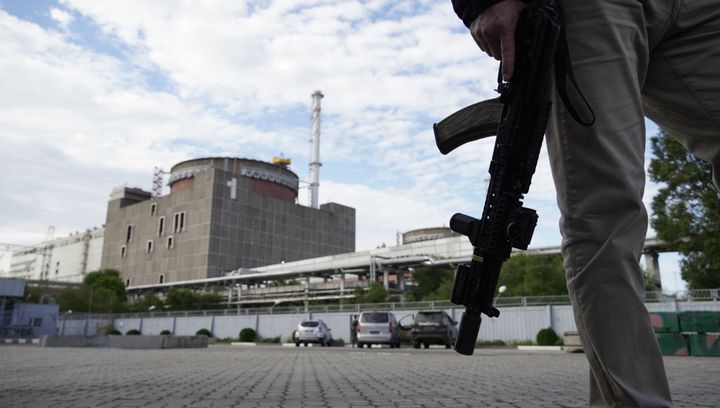This photo taken on September 11, 2022 shows a security person standing in front of the Zaporizhzhia Nuclear Power Plant.
