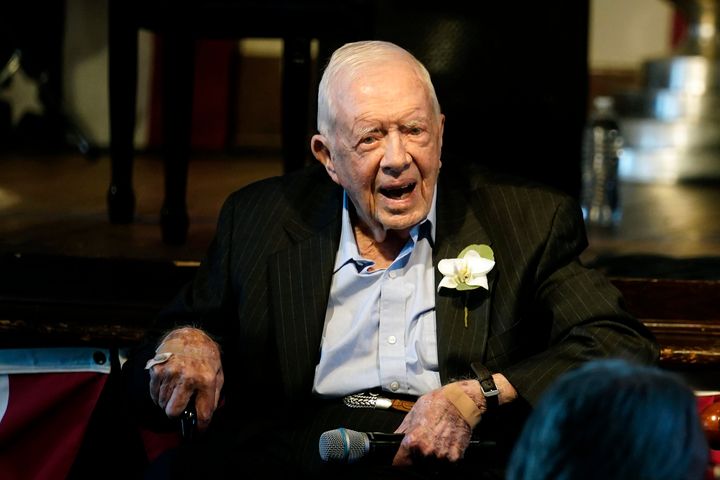 Former President Jimmy Carter reacts as his wife Rosalynn Carter speaks during a reception to celebrate their 75th wedding anniversary Saturday, July 10, 2021, in Plains, Georgia.
