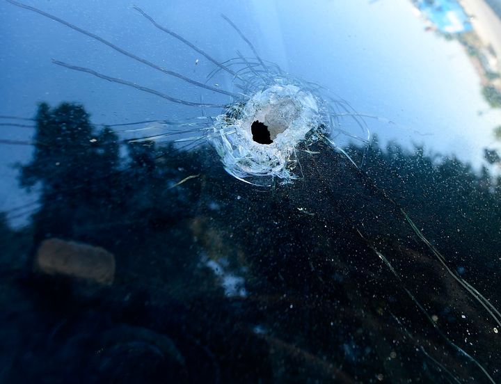 Un trou de balle est vu dans un pare-brise à l'extérieur de l'école élémentaire Cypress après la fusillade à proximité de lundi, qui a fait la mort d'une mère.