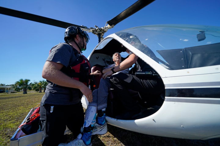 Members of Medic Corps, who arrived with two helicopters, paramedics and volunteers, help evacuate Tom Acerbo in the aftermath of Hurricane Ian on Saturday. The only bridge to Pine Island is heavily damaged so it can only be reached by boat or air.