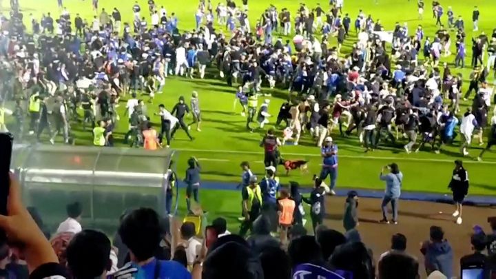 Aficionados invaden un campo de fútbol en Indonesia.