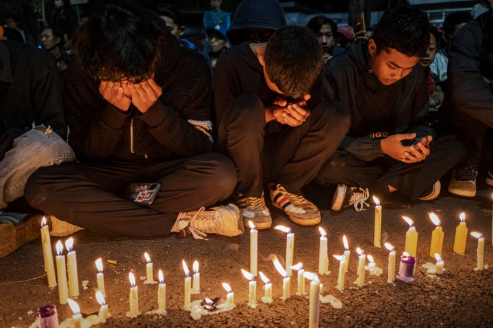Arema FC supporters light candles as they pray for the victims on Oct. 2, 2022 in Malang, Indonesia. A riot and stampede broke out at a soccer stadium in East Java on Saturday. Police fired tear gas to disperse fans who had invaded the pitch after and began fighting the match ended. A stampede for the exits has resulted in at least 125 deaths, media reports said, with many still injured in hospitals.