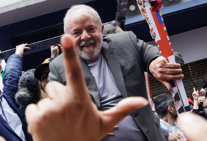 A supporter flashes an "L" hand sign ― a favorite among supporters of Brazil's Luiz Inácio Lula da Silva ― in front of the former president during a campaign rally. Da Silva defeated right-wing President Jair Bolsonaro to win Brazil's presidential election Sunday.