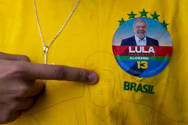 A man wearing a Brazil jersey with a sticker of former Brazilian President Luiz Inacio "Lula" da Silva, who is running for president, poses for a photo during general elections, in Acegua, Brazil, Sunday, Oct. 2, 2022. 