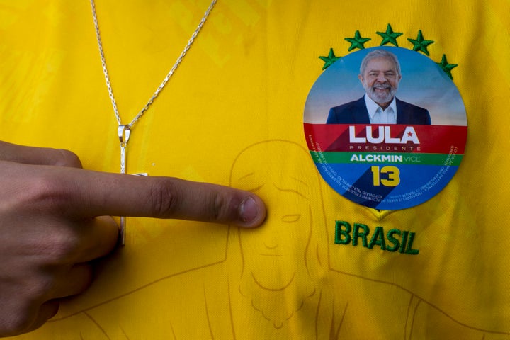 A man wearing a Brazil jersey with a sticker of former Brazilian President Luiz Inacio "Lula" da Silva, who is running for president, poses for a photo during general elections, in Acegua, Brazil, Sunday, Oct. 2, 2022. 