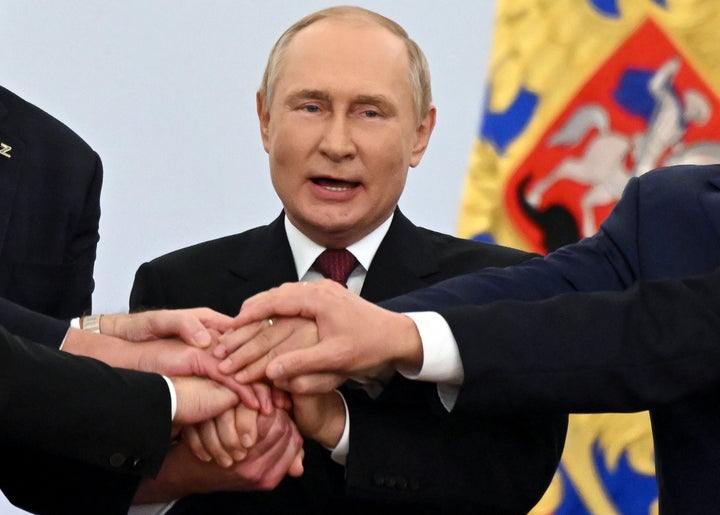 Vladimir Putin, el pasado viernes en Moscú, uniendo las manos de los líderes prorrusos de los cuatro territorios ucranianos que se va a anexionar.