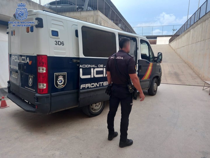 Agente de la policía nacional junto a un furgón.