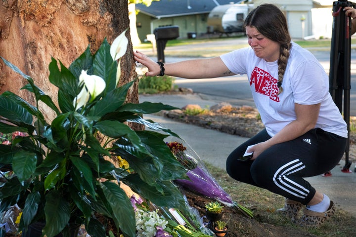 Kayla Kelly grieves as mourners gather and lay flowers and gifts at the site of a deadly car crash during an impromptu memorial service on Sunday in Lincoln, Nebraska.