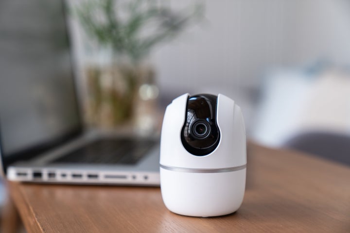 Woman hand presses the phone on the surveillance camera