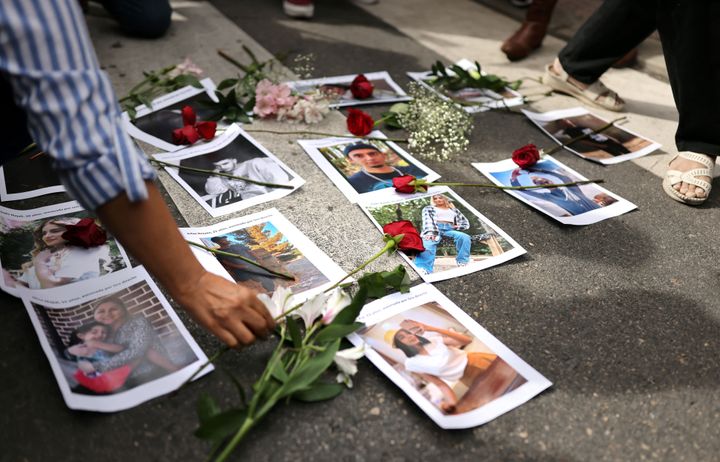 Des manifestants arborent des fleurs sur des photos de victimes lors d'une manifestation devant l'ambassade d'Iran à Madrid, le 28 septembre 2022, à la suite du décès d'une Iranienne après son arrestation par la police des mœurs du pays à Téhéran.