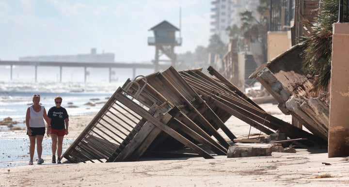 Beachgoers survey the damage on Oct. 3, 2022, in Daytona Beach Shores, Fla., as hotel and condo seawalls and pool decks along the Volusia County coastline were gutted by Hurricane Ian last week.