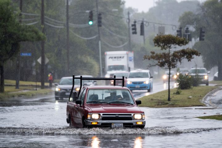 Vehicles make their way through floodwaters caused in part to the remnants of Hurricane Ian in the Larchmont neighborhood of Norfolk, Va., on Oct. 3, 2022. 