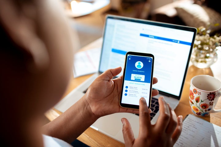 Close up of a mid adult woman using a banking app on her phone