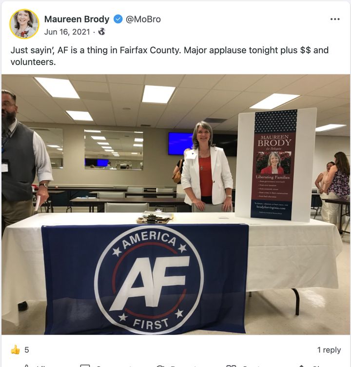 Maureen Brody, a 2021 Republican nominee for the Virginia House of Delegates, poses with a flag for the America First white nationalist movement.