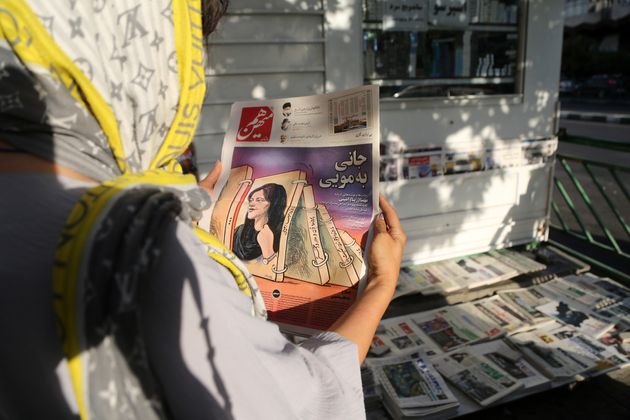 イランの首都テヘランで、アミニさんの死を伝える新聞を手にする（2022年9月18日）