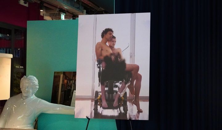 車椅子に乗る二人。実際に下半身が塗り潰される落書きがされた写真を、そのまま飾っているという