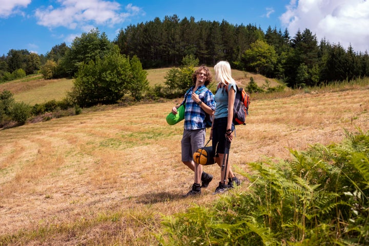 Happy young couple of backpackers enjoying in hiking and camping in the beautiful nature.