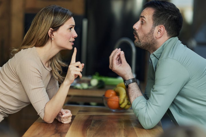 Frustrated couple having an argument in the kitchen.