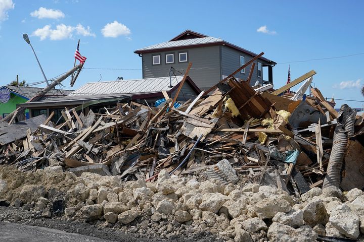 Piles of debris, caused by damage in Hurricane Ian, line the roadway, Thursday, Oct. 6, 2022, in Matlacha, Fla. (AP Photo/Wilfredo Lee)