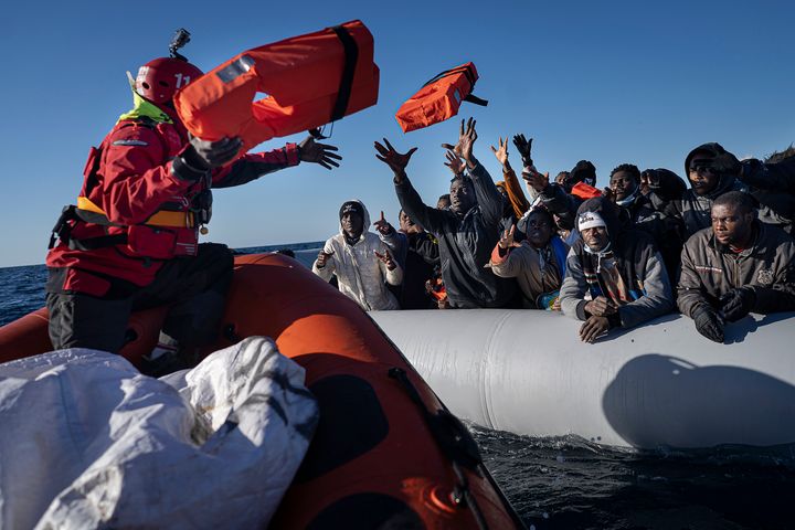 ΑΡΧΕΙΟ - Μετανάστες και πρόσφυγες από την Αφρική που πλέουν παρασυρόμενοι σε μια υπερπλήρη λαστιχένια βάρκα, λαμβάνουν σωσίβια από τους εργαζόμενους της ισπανικής ΜΚΟ Aita Mary στη Μεσόγειο Θάλασσα, περίπου 103 μίλια (165 χλμ.) από τις ακτές της Λιβύης, 28 Ιανουαρίου 2022. Τα δύο ναυάγια πλοίων μεταναστών στα ανοιχτά της Ελλάδας που άφησαν νεκρούς τουλάχιστον 22 ανθρώπους αυτή την εβδομάδα έστρεψαν για άλλη μια φορά τα φώτα της δημοσιότητας στους κινδύνους της μεσογειακής μεταναστευτικής διαδρομής προς την Ευρώπη. (AP Photo/Pau de la Calle, file)