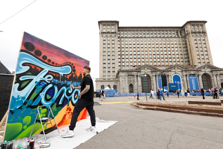 Un artiste peint une toile à la gare centrale historique du Michigan, vieille de 105 ans, avant une conférence de presse de Ford Motor Company pour annoncer officiellement son intention de rénover le bâtiment et de le transformer, ainsi que le quartier Corktown de Detroit, en une plaque tournante pour la technologie automobile de Ford sur 19 juin 2018 à Détroit, Michigan.