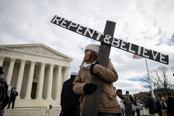 An anti-abortion advocate holds a cross outside of the Supreme Court during the March for Life, Jan. 27, 2017, in Washington, D.C.