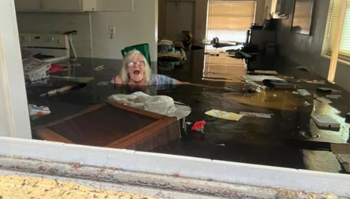 In this photo provided by Johnny Lauder, Lauder's mother, Karen Lauder, 86, is submerged nearly to her shoulders in water that has flooded her home, in Naples, Florida, Wednesday, Sept. 28, 2022, following Hurricane Ian.