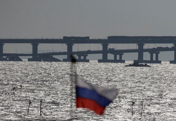 Η ρωσική εθνική σημαία κυματίζει με φόντο τη γέφυρα του Κερτς μετά από έκρηξη που κατέστρεψε μέρος της, στο στενό του Κερτς, Κριμαία, 8 Οκτωβρίου 2022. REUTERS/Stringer