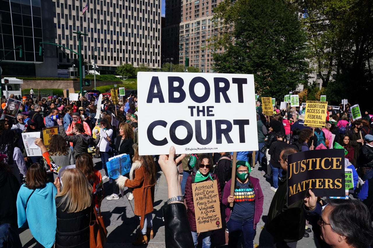 Demonstrators hold signs criticizing the U.S. Supreme Court in New York City.