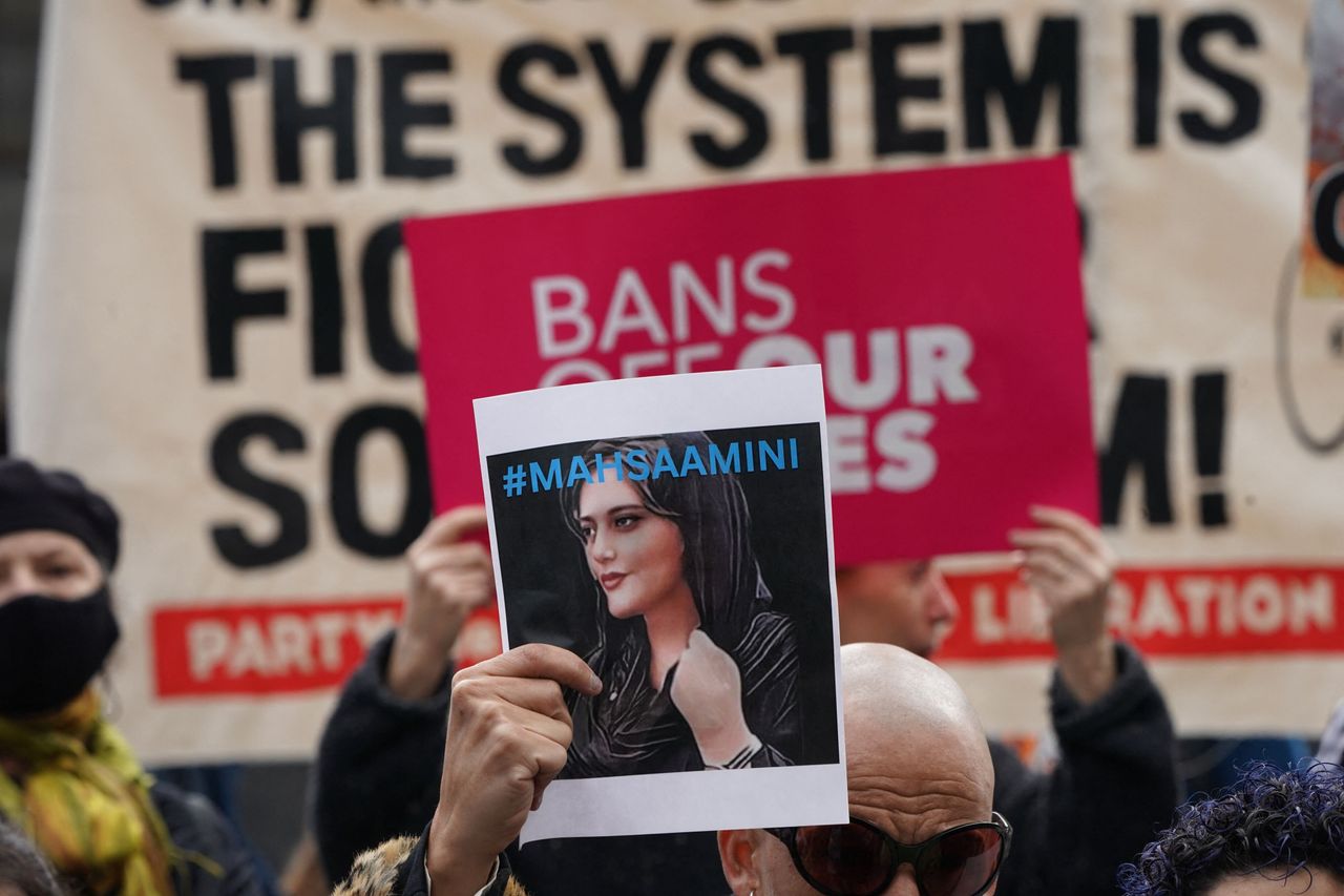 A demonstrator in New York City holds up a photo of Mahsa Amini in solidarity with protesters in Iran fighting for women's rights. The 22-year-old Amini was killed in the custody of Iran's religious police for improperly wearing her headscarf. Her death in mid-September has sparked weeks of heated protests. 