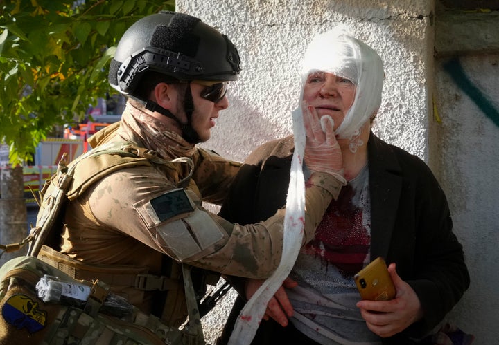 An injured woman receives medical treatment at the scene of Russian shelling, in Kyiv, Ukraine, on Oct. 10, 2022.