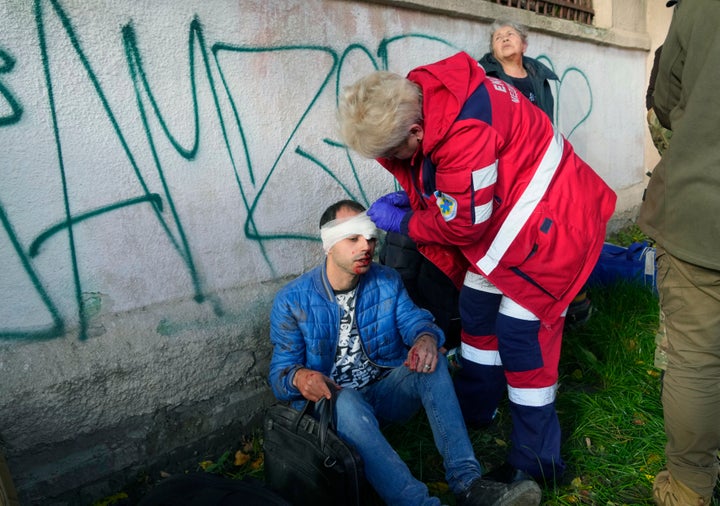 Des personnes reçoivent des soins médicaux sur les lieux des bombardements russes à Kyiv, en Ukraine, le 10 octobre 2022. 