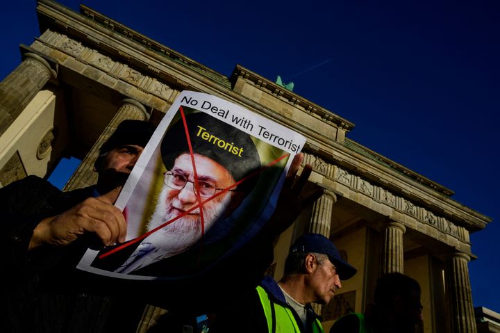 A demonstrator displays a portrait of Iran's supreme leader Ali Khamenei and the word "terrorist" during a rally in Berlin on Oct. 7, 2022. 